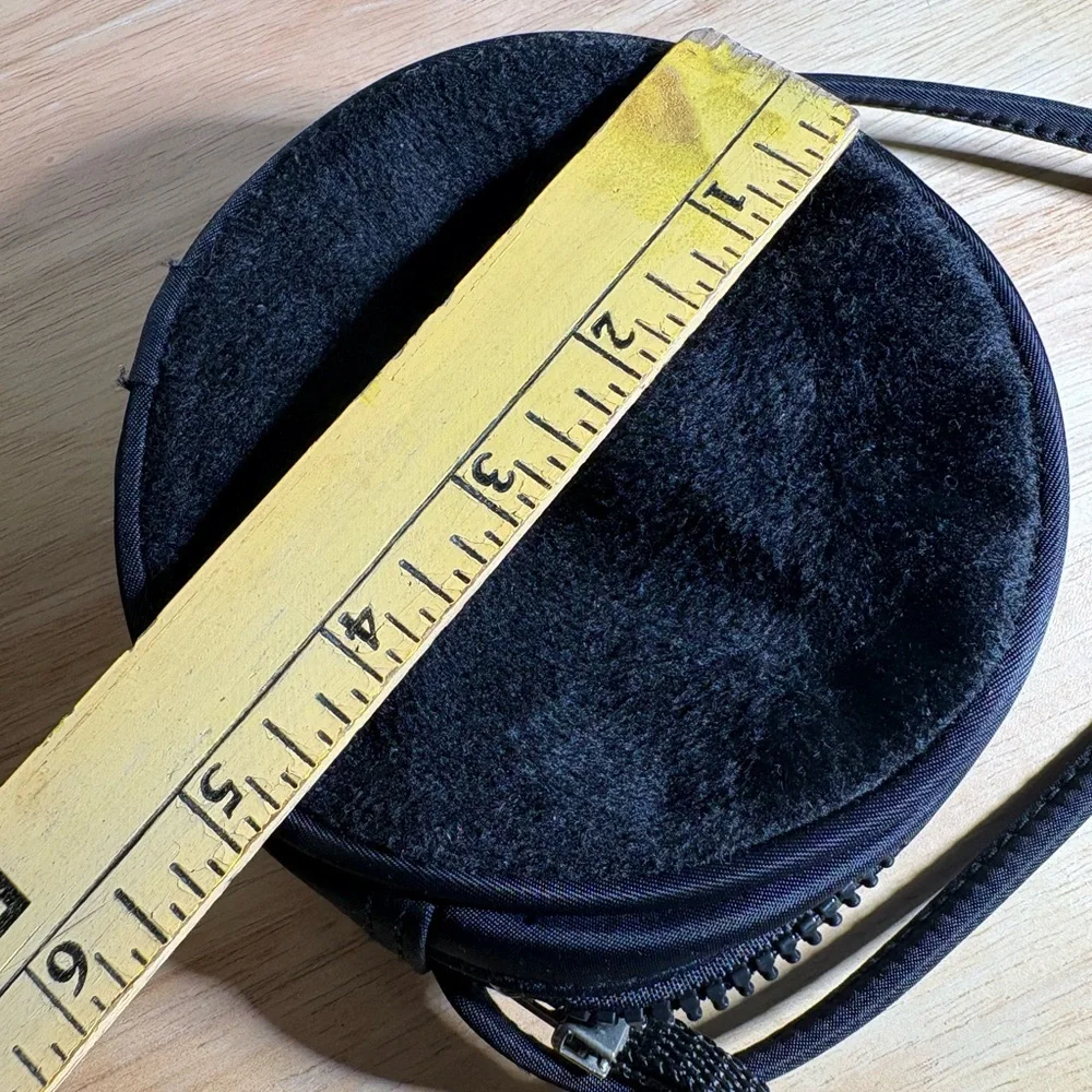 Women’s Round Black Crossbody Bag with zipper closure.